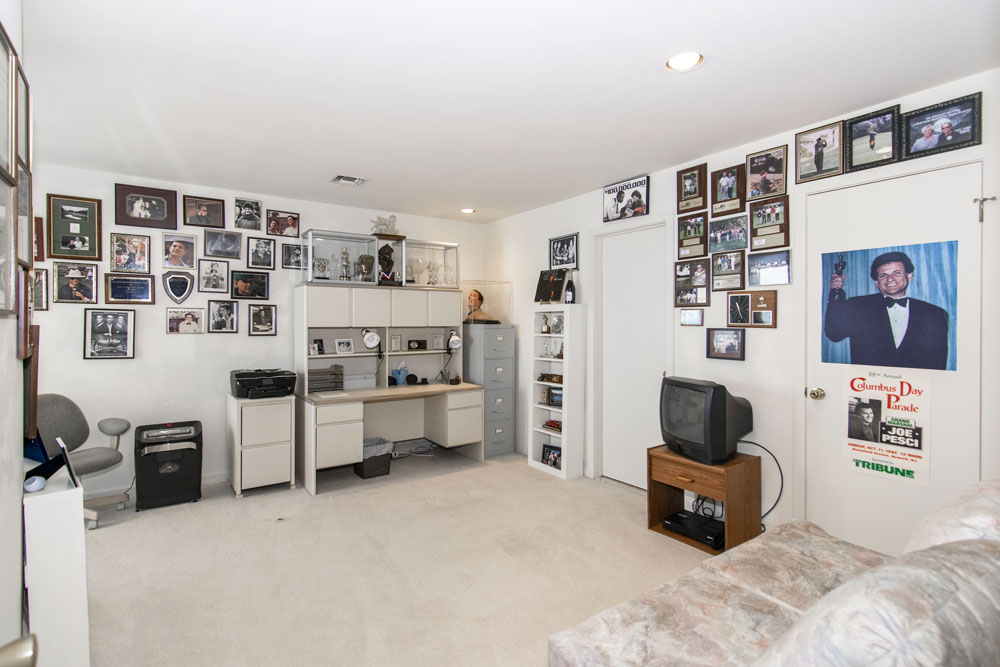 An old-school home office with carpeting, tiny TV, steel filing cabinets and various posters and plaques