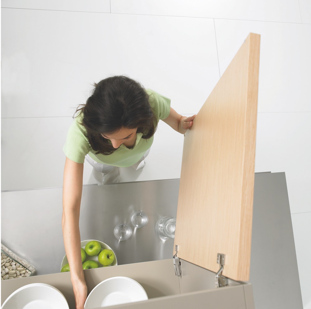 top view of woman taking dishes out of kitchen cabinet