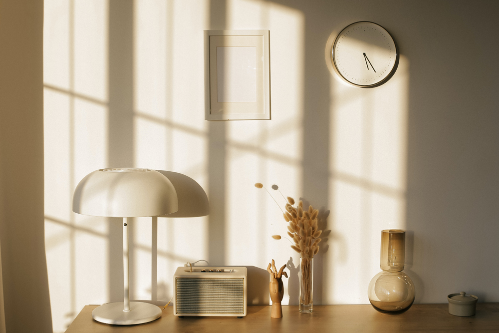 a small white minimalist clock on the wall of a bedroom