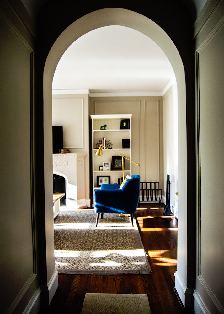 dark archway hallway leading into light living room