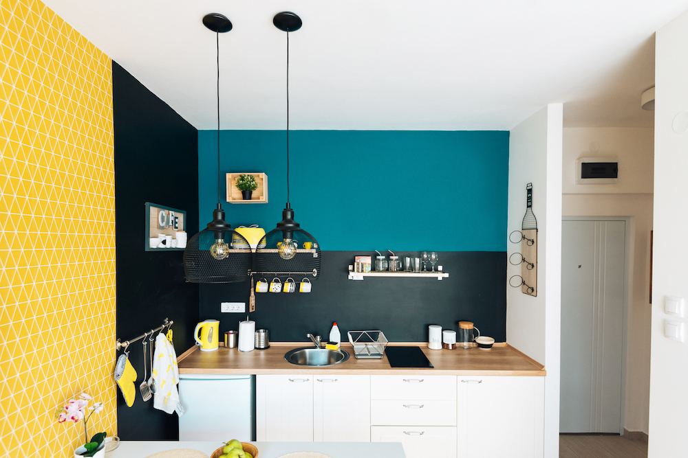 dark-wall kitchen beside bright yellow wall in apartment kitchen