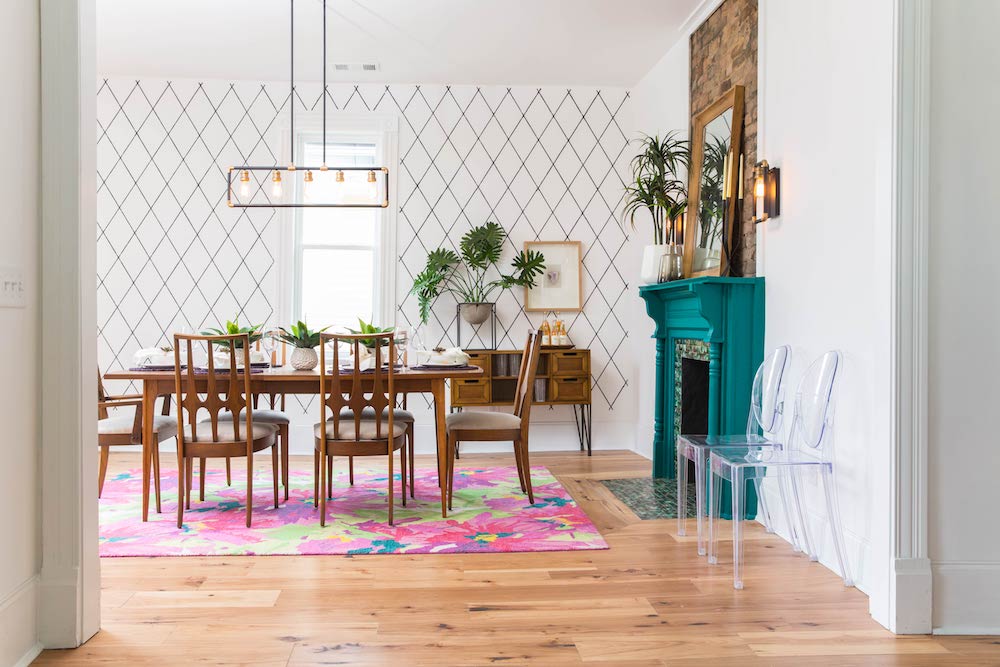 Dining room with colourful area rug and bright teal fireplace.