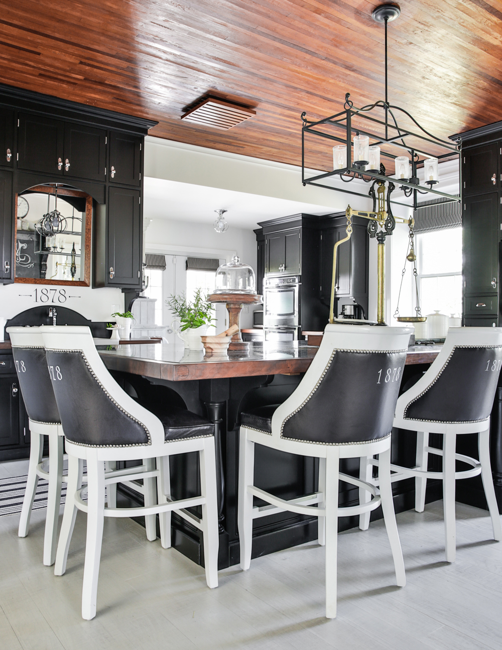 Renovated kitchen with soaring wood ceilings and stark black cabinetry