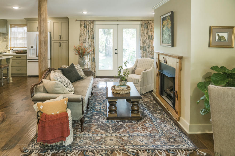 open concept living room with patterned area rug and sunflower painting