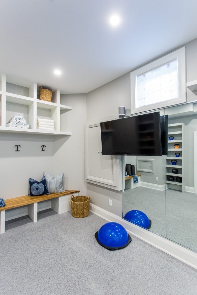 Gym in basement with wall of mirrors