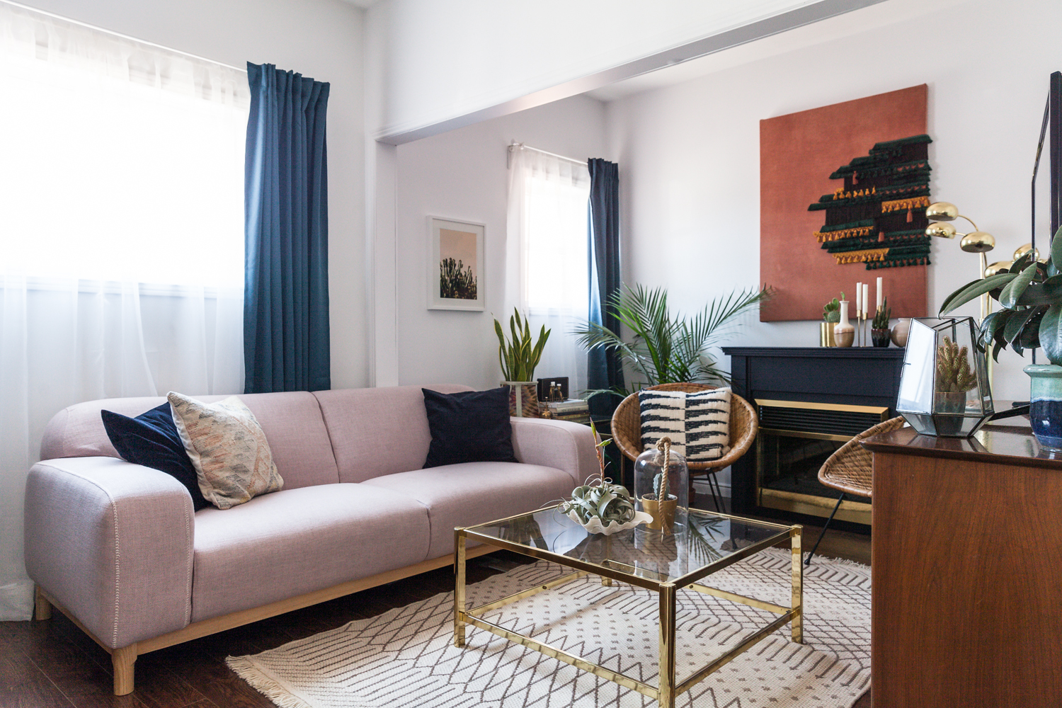 living room with lavender sofa, blue drapes and black and brass fireplace