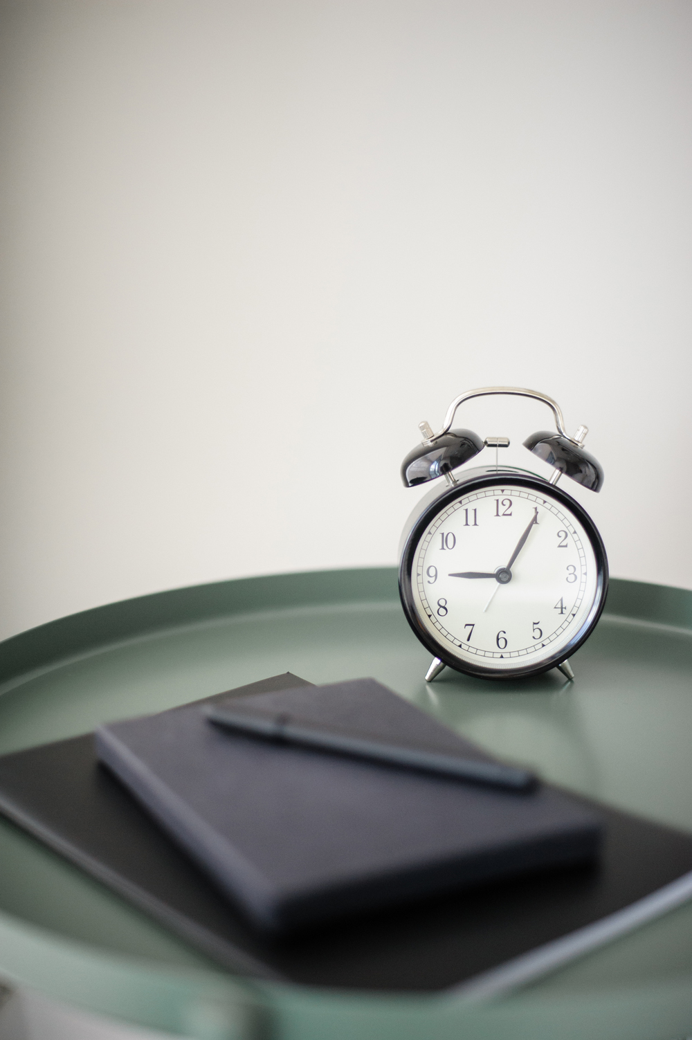 Bedside table with notebook and alarm clock