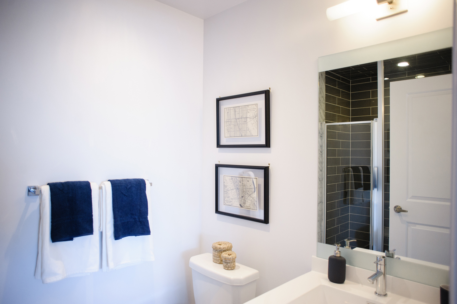 Masculine guest bathroom with black subway tile shower