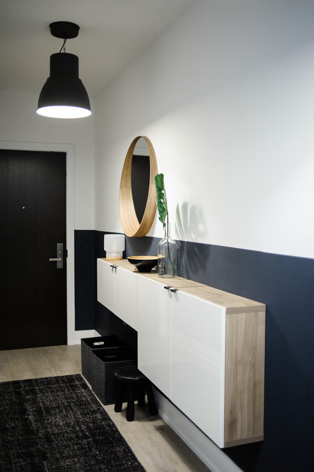 A condo entryway with a half black and half white wall