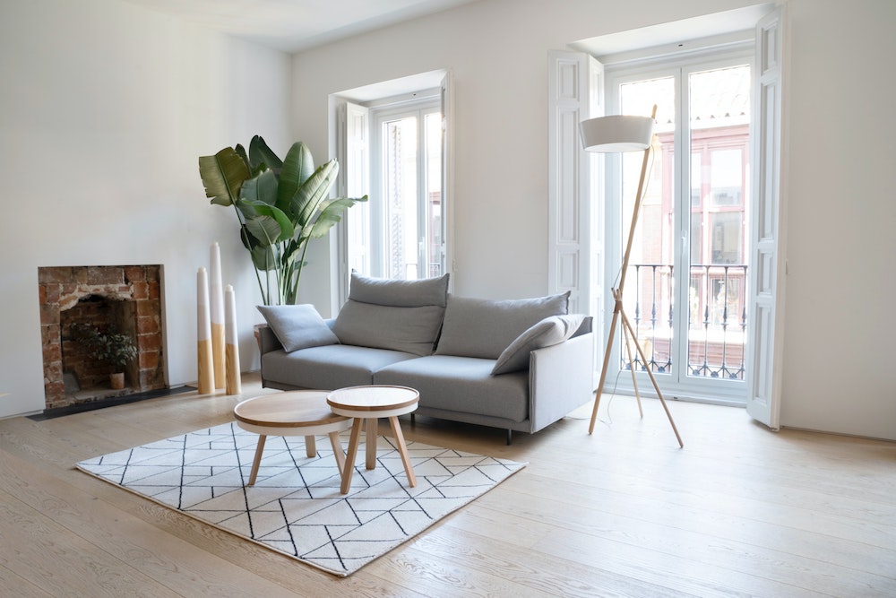 minimal living room with grey couch and two small round coffee tables