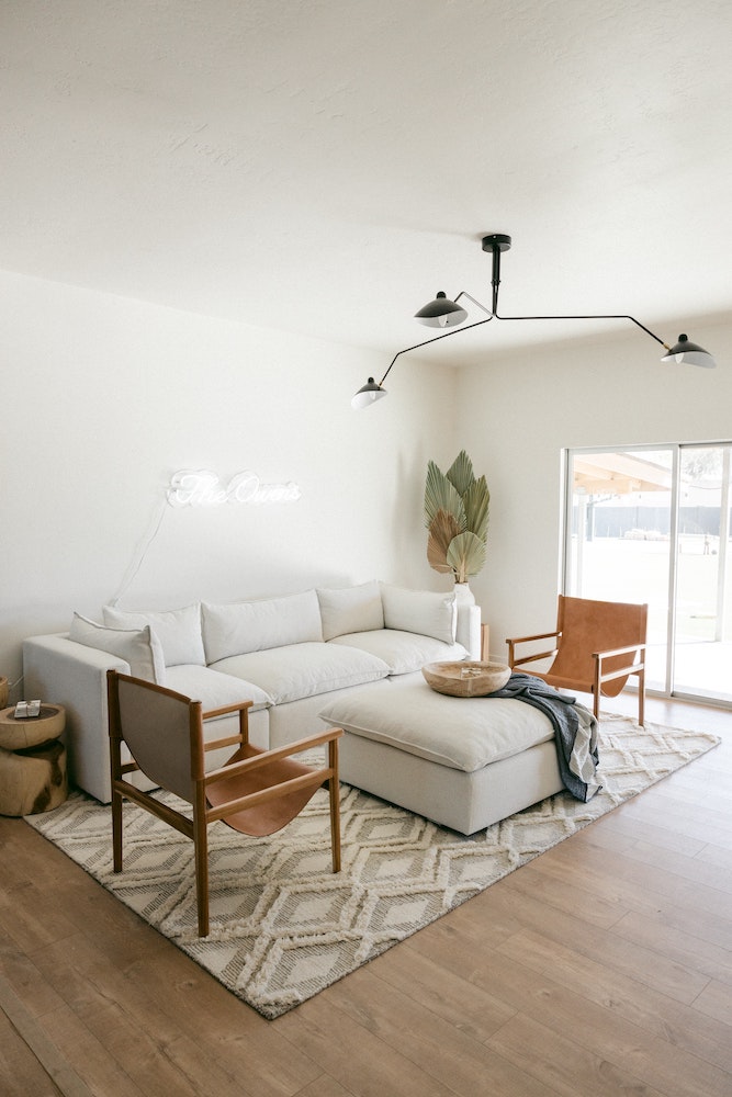 neutral living room with white couch and neon light on wall