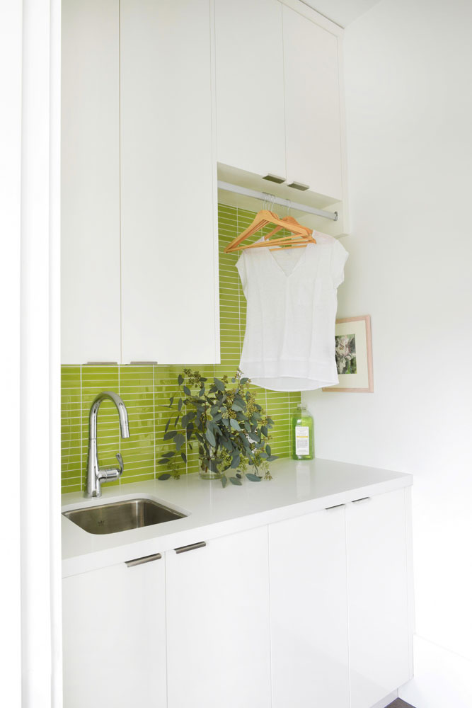 Small laundry room with lime green glass tile backsplash.