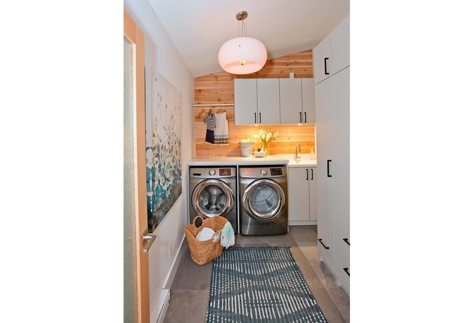 Wooden laundry room design with blue runner and lots of storage.