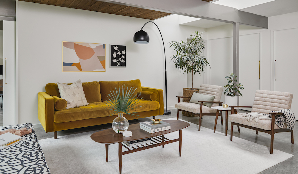 Gold-velvet Article sofa in living room with two open-armed chairs and a coffee table