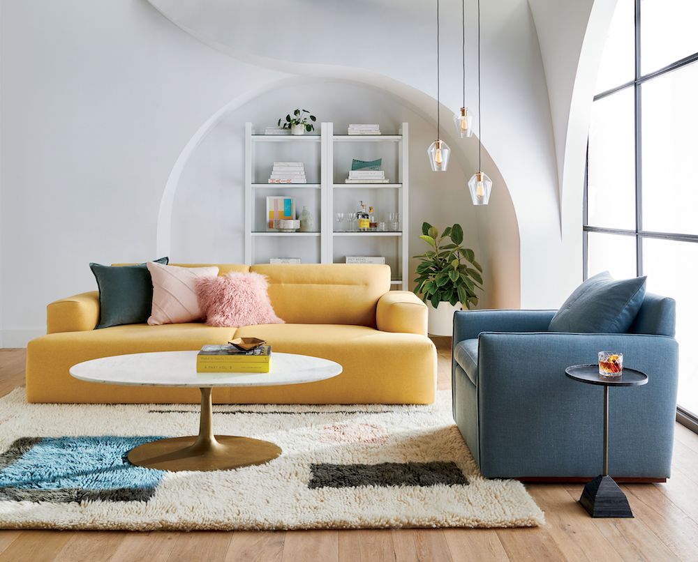 Big yellow sofa in modern living room with blue chair