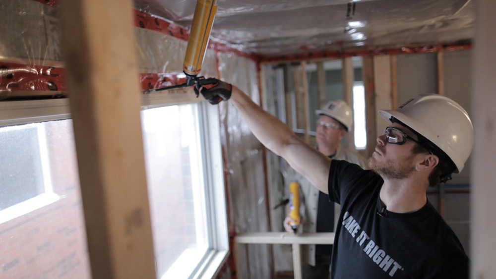 Mike Holmes Jr caulking a window