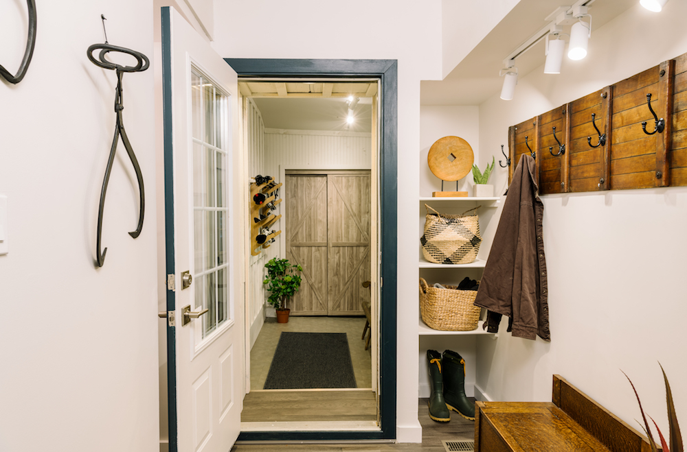 A country-style renovated mudroom with a vintage toboggan converted into a playful coat rack