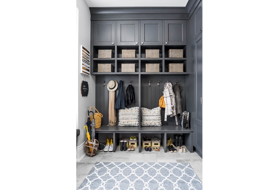 Mudroom with grey floor, blue rug and lots of storage