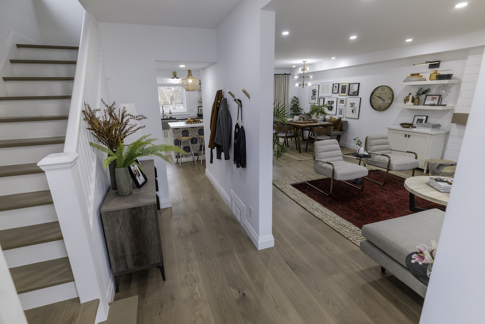 open front entrance with hooks on wall and view of living room, dining room and kitchen