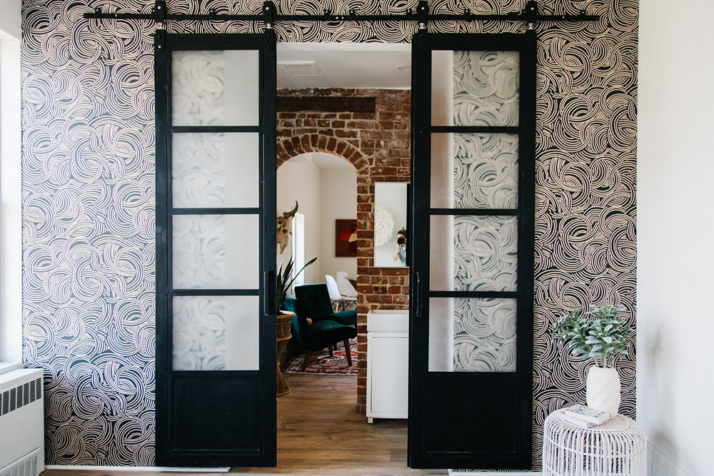 Bold wallpaper and sliding doors leading into the living area