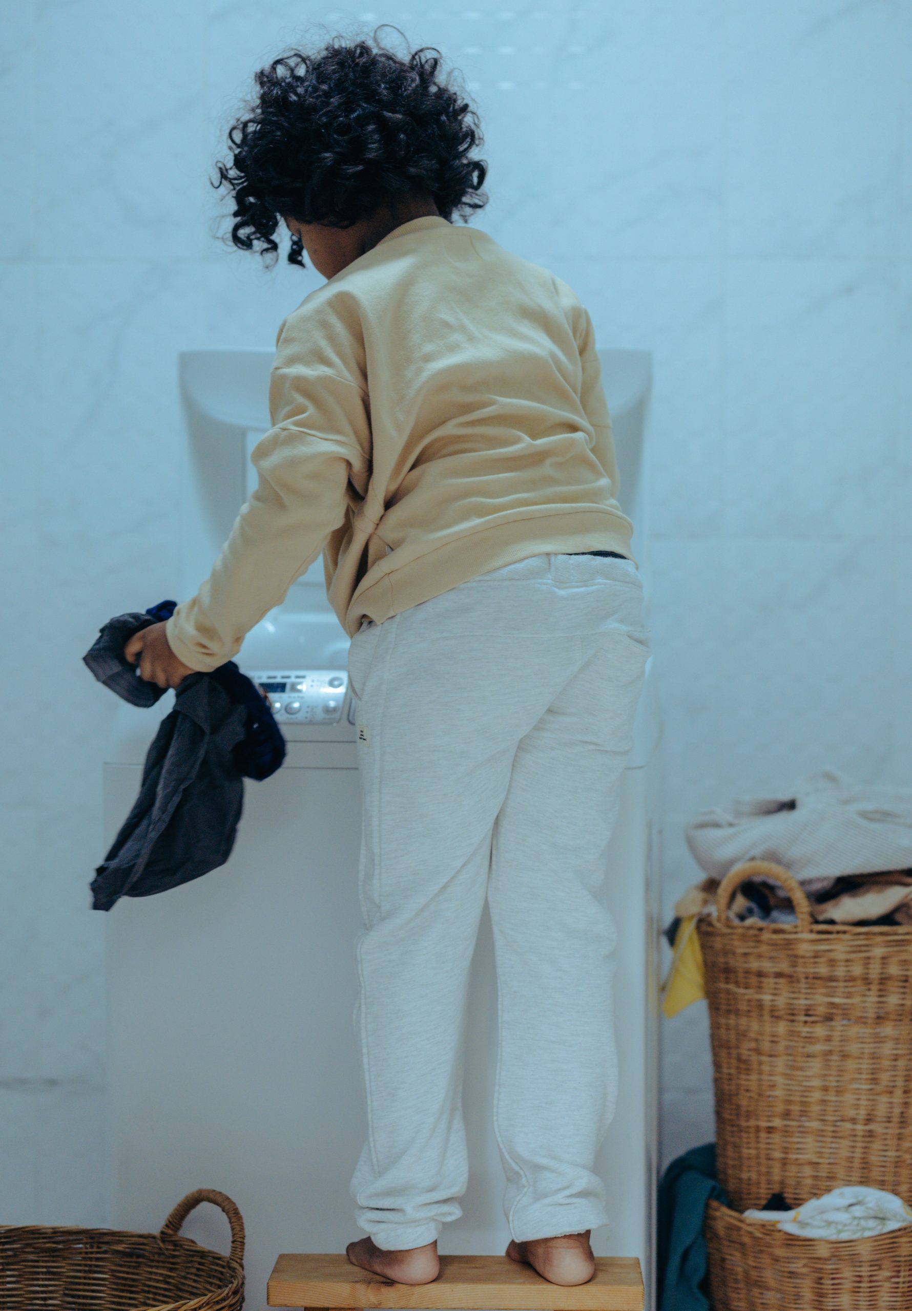 Boy filling washing mashine