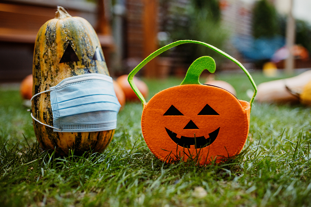 Pumpkins on the grass with face protective mask during Covid-19 pandemic