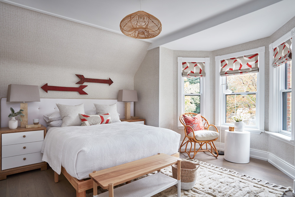 Bedroom with queen-size bed and pops of orange in the decor and window curtains