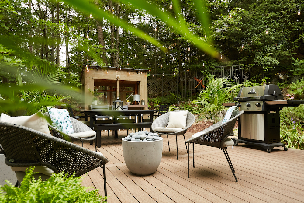 backyard beer garden with deck, bar, seating area and BBQ surrounded by green trees