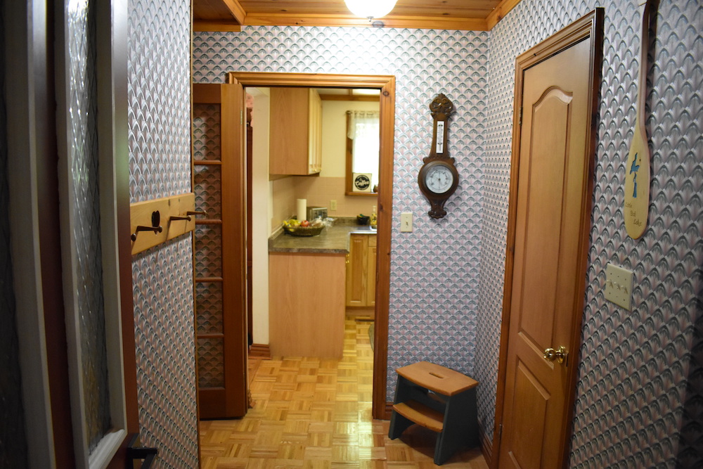 outdated mudroom with multi-colour wallpaper