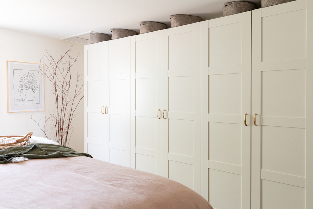 row of tall white cabinets in cozy bedroom