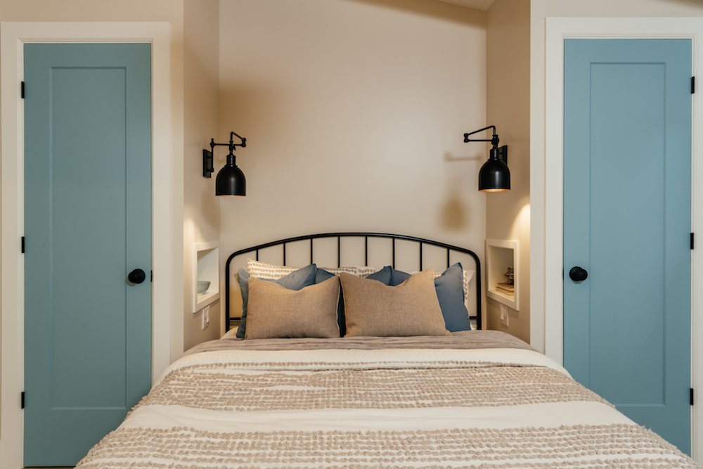 cozy beige bedroom with black sconces framing bed