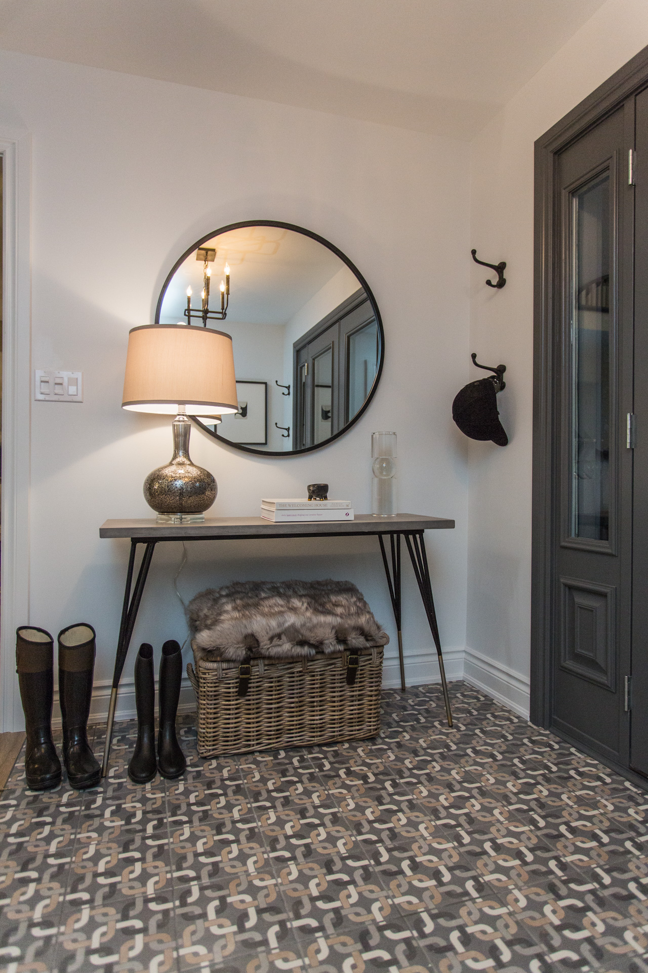 entranceway with earthy-toned geometric tile, classic furnishings and big hooks.