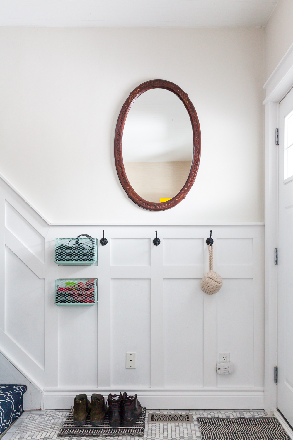 Farmhouse with patterned staircase and organized entryway.