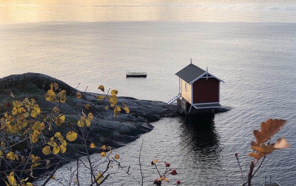 tiny red house at water's edge