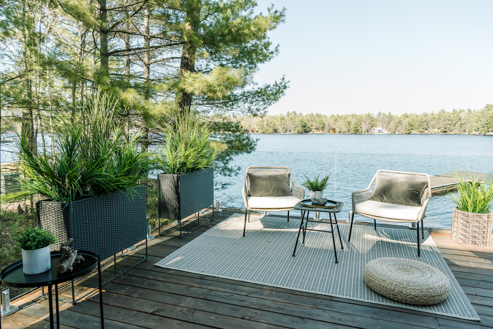 Deck with glass railing and seating area overlooking lake