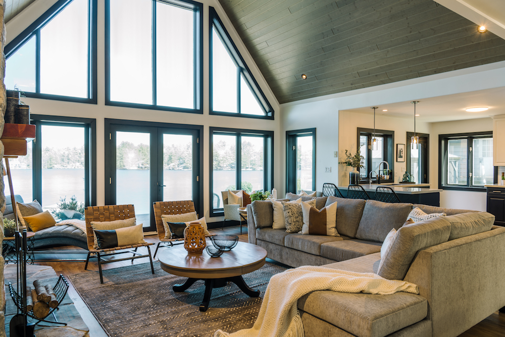 Large living room with grey sofa and view of lake