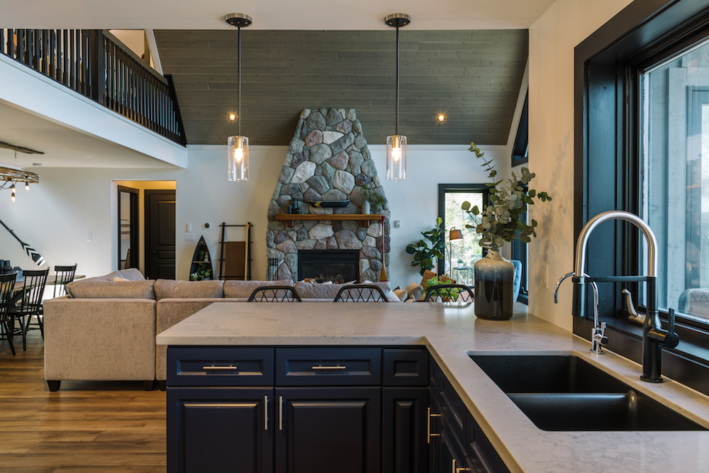 View of stone fireplace in living room from kitchen