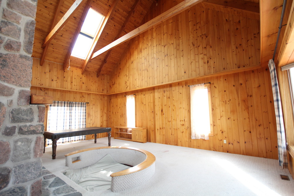 Wood cottage empty living room with white carpet floors