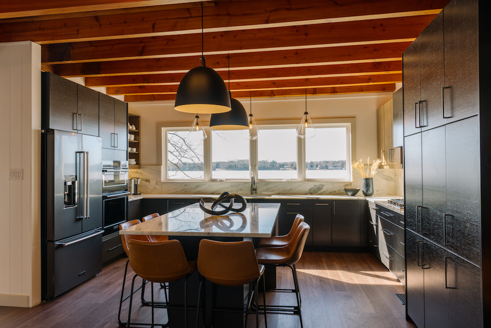 Updated executive kitchen with dark cabinets and large table