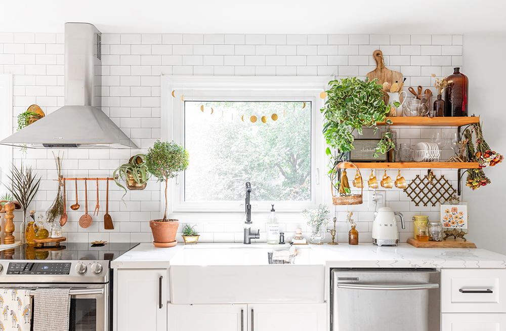 Bite-Sized Boho A pristine white kitchen with open shelving and plenty of plants