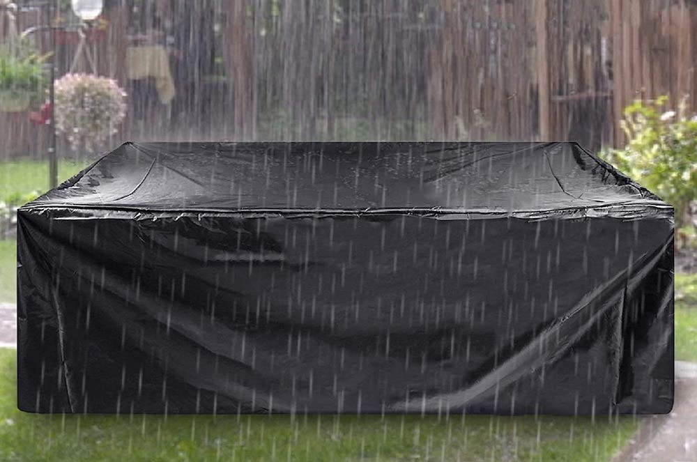 black furniture cover over outdoor furniture on grass on rainy day