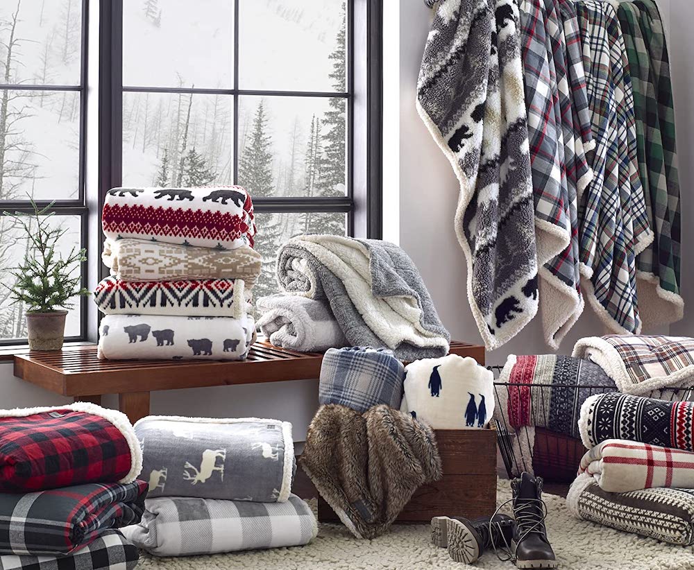 assortment of cozy throw blankets in mud room with snowy day in background outside window