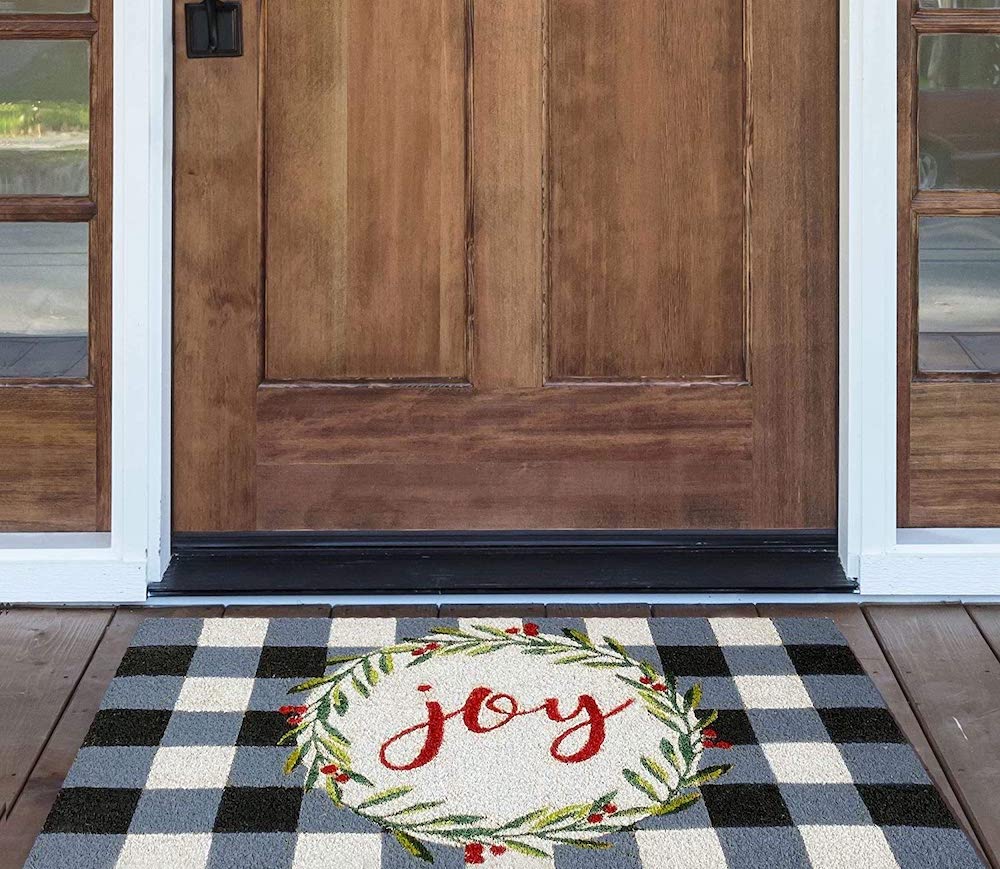 plaid doormat on wooden porch outside wooden front door of house