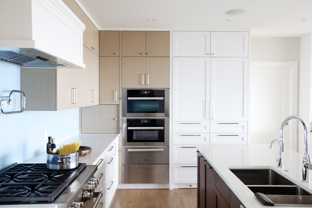 Modern kitchen design with warm wood and white upper cabinets.