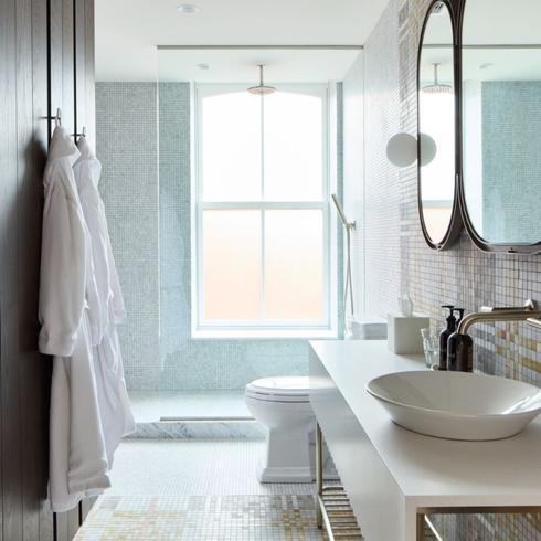 Bathroom with black mirrors, white tiles and modern closet