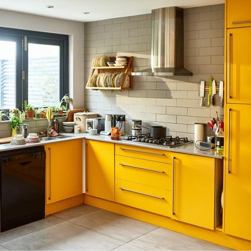 A kitchen with bright yellow cabinets