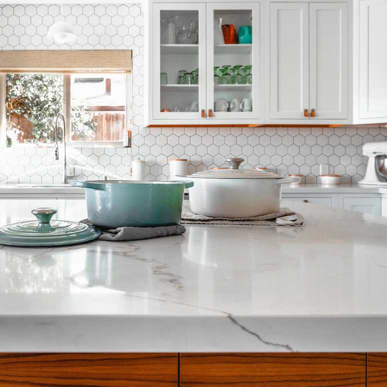 Bright kitchen with white cabinets and two cabinet doors with clear glass