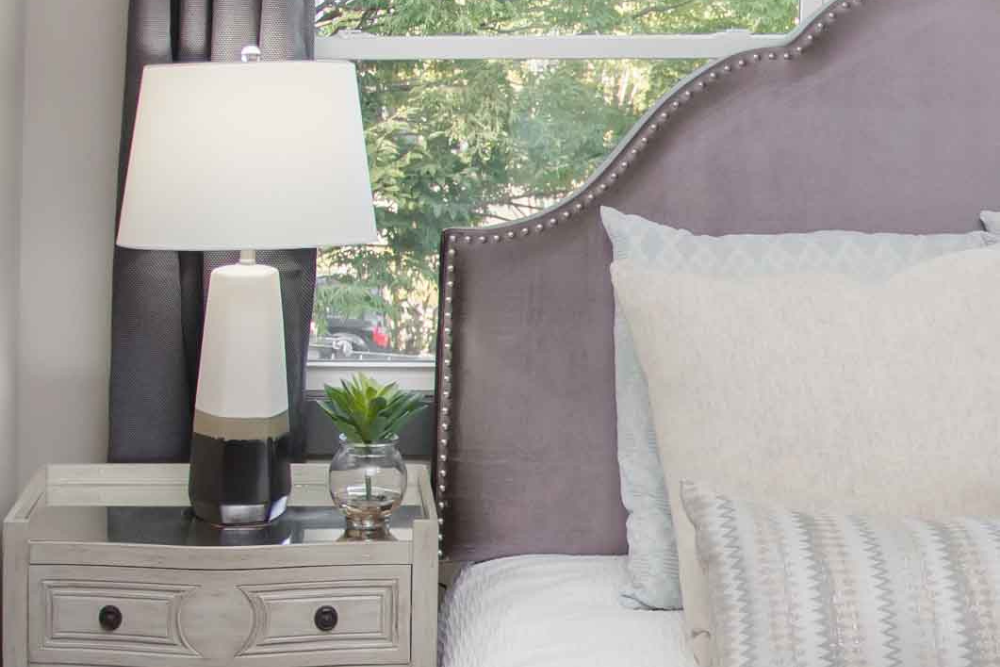 A bedroom that utilizes lilac via an upholstered headboard