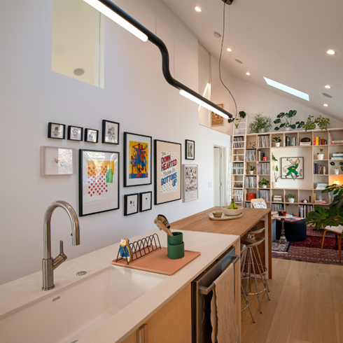 A modern open-concept kitchen with a white island and sink