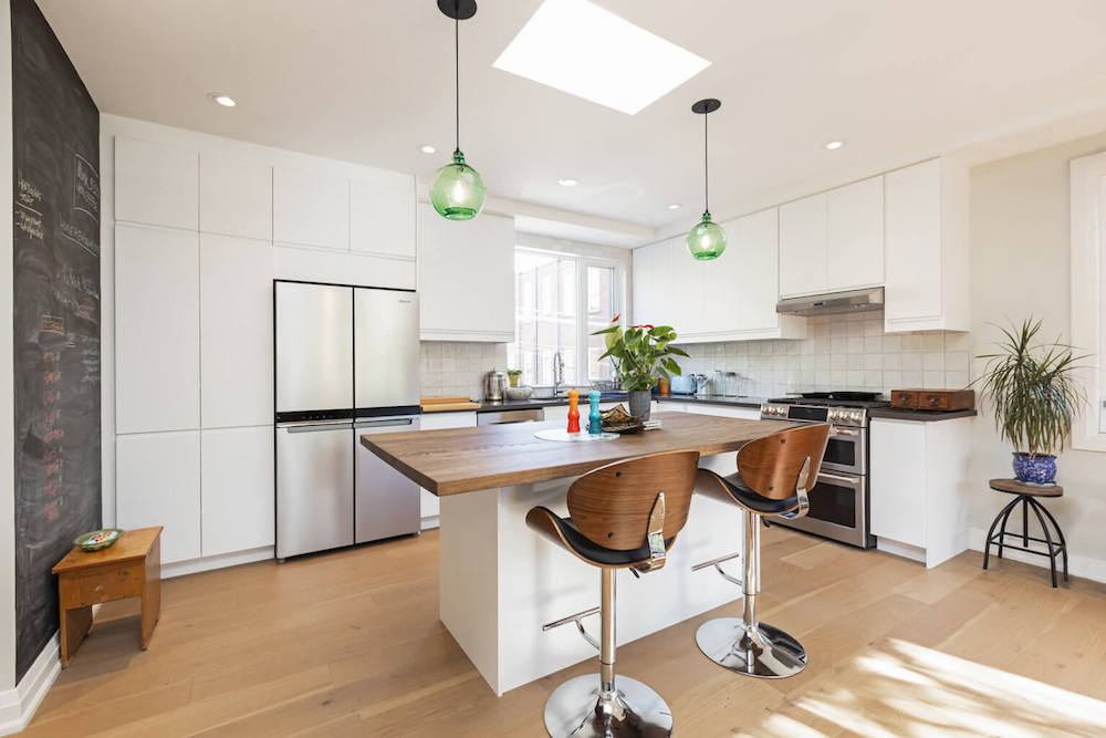 White kitchen in laneway house with flat-front cabinetry